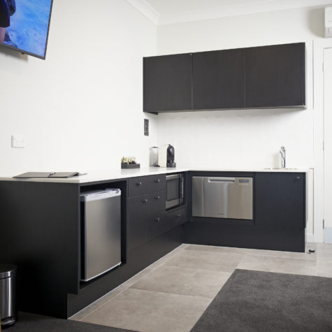 Kitchenette with bar fridge, microwave and dishwasher