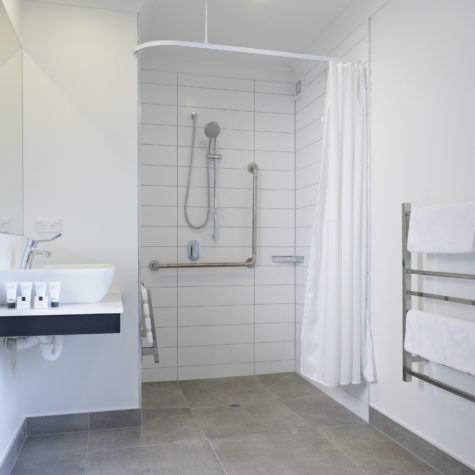 Tiled walk in shower, vanity and guest toiletries